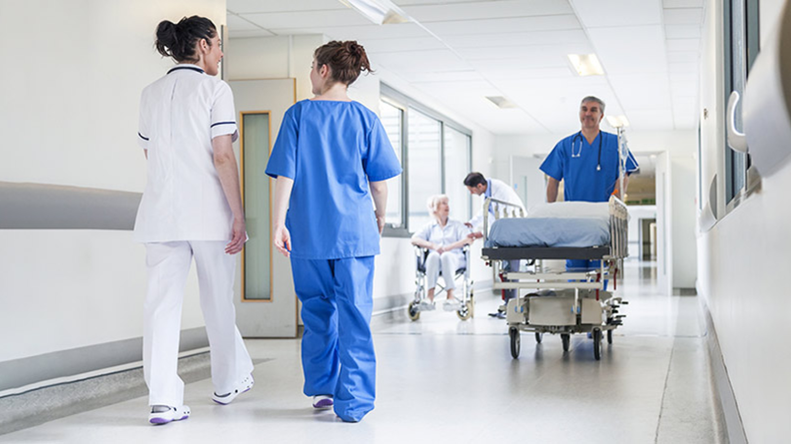 Nurses with patient in hospital corridor